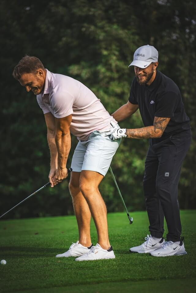 生徒にスイングレッスンをしているレッスンプロの様子